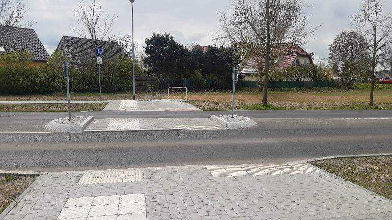 Ein barrierefreier Fussgaengerueberweg mit Mittelinsel in einem Wohngebiet